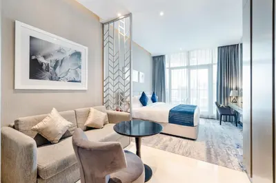 a hotel room with a couch and a bed at A Living-Modern Studio Apartment with Balcony & Canal view at Prive 2507B ,Business Bay in Dubai