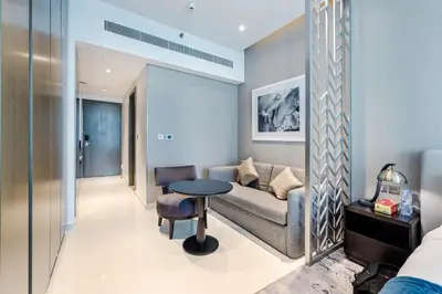 a living room with a couch and a table at A Living-Modern Studio Apartment with Balcony & Canal view at Prive 2507B ,Business Bay in Dubai