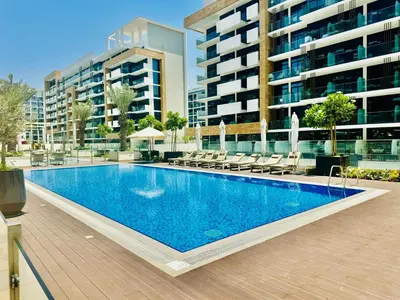 a swimming pool in front of a building at Venduras - Modern Chic Studio in Azizi Riviera in Dubai