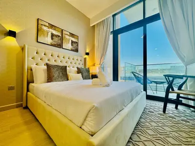a bedroom with a large bed and a large window at Venduras - Modern Chic Studio in Azizi Riviera in Dubai