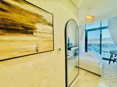 a bedroom with a bed and a painting on the wall at Venduras - Modern Chic Studio in Azizi Riviera in Dubai