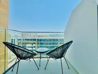 a balcony with two chairs and a table on it at Venduras - Modern Chic Studio in Azizi Riviera in Dubai