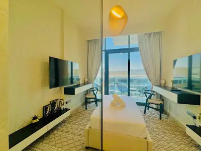a hotel room with a bed and a flat screen tv at Venduras - Modern Chic Studio in Azizi Riviera in Dubai