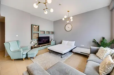 a living room with a couch and a clock on the wall at Luxury 2Bedroom with Stunning Sea View in JBR in Dubai