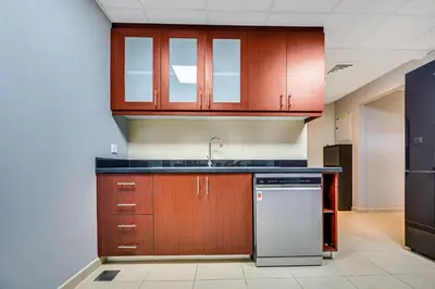 a kitchen with wooden cabinets and a white dishwasher at Luxury 2Bedroom with Stunning Sea View in JBR in Dubai