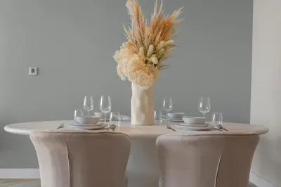 a table with chairs and a vase with flowers on it at Luxurious Living in a 2 Bedroom at Forte Downtown in Dubai