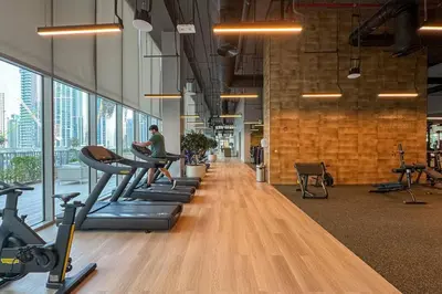 a gym with a person exercising on treadles in a gym at Luxurious Living in a 2 Bedroom at Forte Downtown in Dubai