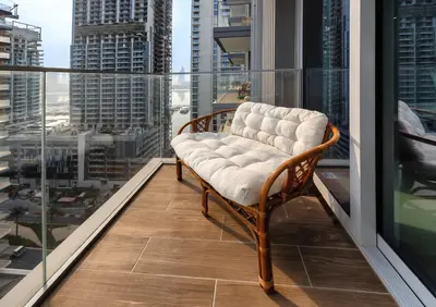 a chair on a balcony with a view of a city at Stunning 2 Bedroom in Emaar Beachfront in Dubai