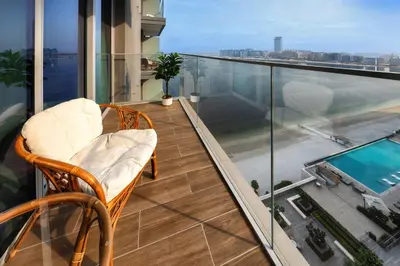 a balcony with two chairs and a view of a pool at Stunning 2 Bedroom in Emaar Beachfront in Dubai