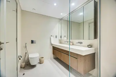a bathroom with a sink and a toilet and a mirror at Stunning 2 Bedroom in Emaar Beachfront in Dubai