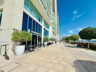 a street outside of a building with tables and chairs at Stunning 2 Bedroom in Emaar Beachfront in Dubai