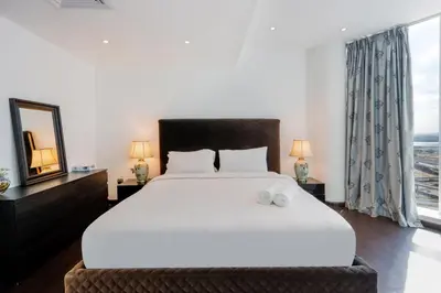 a bedroom with a large white bed and a window at Livbnb - Contemporary Suite with Private Plunge Pool in Dubai