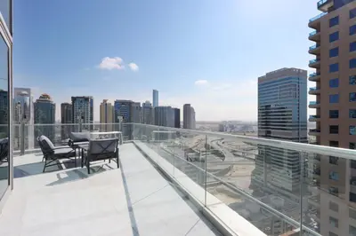a balcony with two chairs and a view of the city at Livbnb - Contemporary Suite with Private Plunge Pool in Dubai