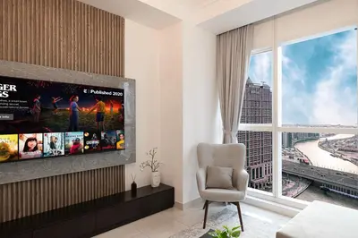 a living room with a tv and a large window at Luxurious 1BR in Court Tower Business Bay in Dubai