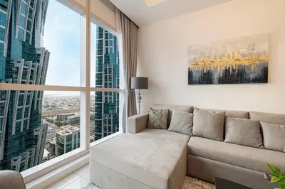 a living room with a couch and a large window at Luxurious 1BR in Court Tower Business Bay in Dubai