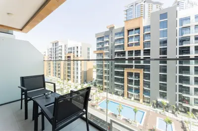 a balcony with a table and a view of a building at HAVN - 1 Bedroom Unit in Azizi Riviera, Meydan in Dubai