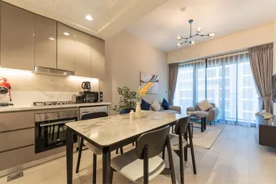 a kitchen and living room with a table and chairs at HAVN - 1 Bedroom Apartment in Azizi Riviera in Dubai