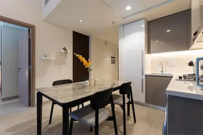 a dining room with a table and chairs and a kitchen at HAVN - 1 Bedroom Apartment in Azizi Riviera in Dubai