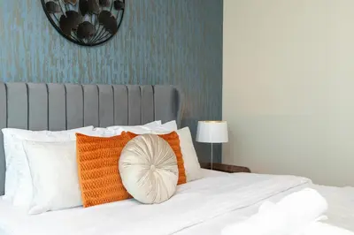 a bed with orange and white pillows on it at Sunrise Bay Tower 2 - Beachfront Spectacular Two Bedroom with Private Beach Access in Dubai