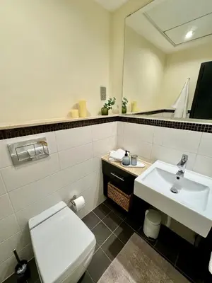 a bathroom with a white toilet and a sink at Modern 1BR with Balcony, Pool and Gym, Dubai Marina in Dubai