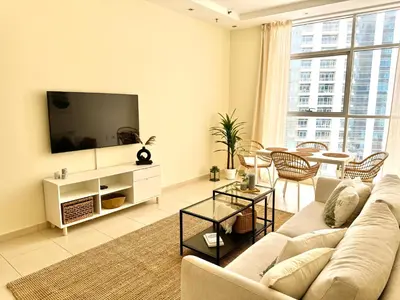 a living room with a couch and a tv at Modern 1BR with Balcony, Pool and Gym, Dubai Marina in Dubai
