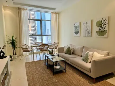 a living room with a couch and a table at Modern 1BR with Balcony, Pool and Gym, Dubai Marina in Dubai