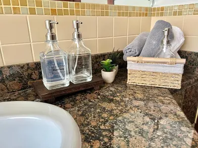 a bathroom with two bottles on a counter next to a sink at High Floor 1BR Apartment with breathtaking sea views of AIN Dubai in Dubai