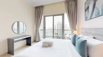 a bedroom with a white bed and a large window at Bay Central - One Bedroom with Marina View in Dubai