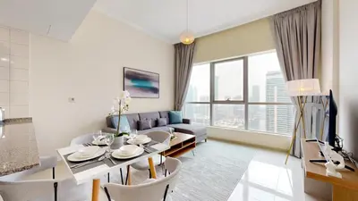 a living room with a table and a couch at Bay Central - One Bedroom with Marina View in Dubai