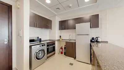 a kitchen with a refrigerator and a dishwasher at Bay Central - One Bedroom with Marina View in Dubai