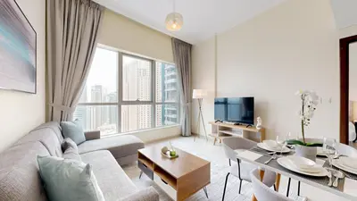 a living room with a couch and a table at Bay Central - One Bedroom with Marina View in Dubai