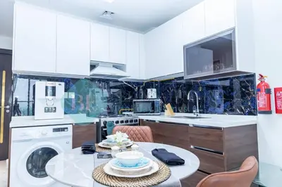 a kitchen with a table and a washing machine at Bloomfields Hidden Gem Studio In Arjan in Dubai