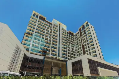 a tall building with a blue sky in the background at Bloomfields Hidden Gem Studio In Arjan in Dubai