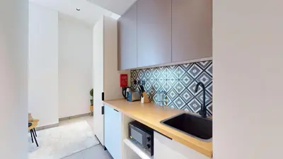 a kitchen with white cabinets and a sink at The Community Jumeirah Village in Dubai