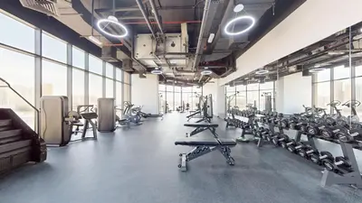 a gym with a lot of treadmills and machines at The Community Jumeirah Village in Dubai