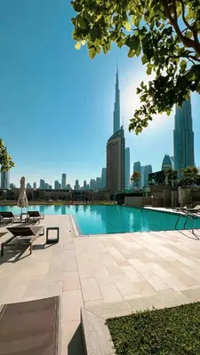 a swimming pool with a city skyline in the background at Stunning Two-Bedroom Apartment with Skyline View & walk to Dubai Mall by TerraHome in Dubai