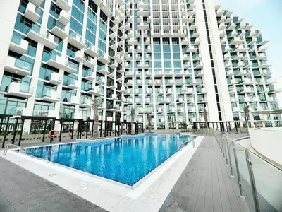 a swimming pool in front of a large building at Farhad Azizi Residence - Al Jaddaf by Golden Casa in Dubai