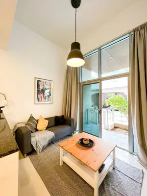 a living room with a couch and a table at Beautiful studio apartment in Dubai