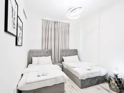 two beds in a room with white walls at StoneTree - Fully Furnished - Dania 2 in Dubai