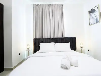 a white bedroom with a large white bed with white pillows at StoneTree - Fully Furnished - Dania 2 in Dubai