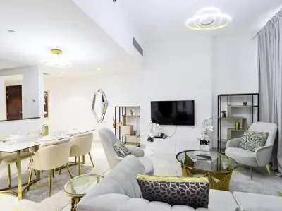 a living room with white furniture and a tv at StoneTree - Fully Furnished - Dania 2 in Dubai