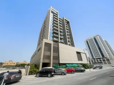 a parking lot with cars parked in front of a building at StoneTree - Newly Furnished - Al Furjan in Dubai
