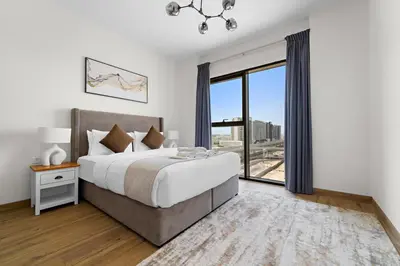 a bedroom with a large bed and a large window at StoneTree - Newly Furnished - Al Furjan in Dubai