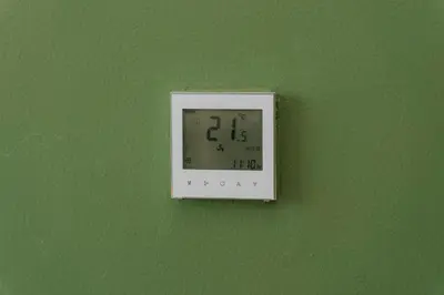 a clock hanging on a green wall at Elite Escape - 1 BHK Getaway in Azizi Riviera in Dubai