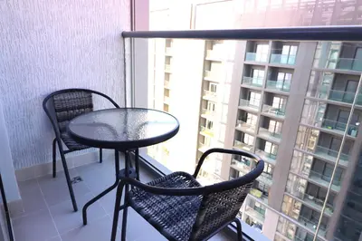 a table and two chairs on a balcony with a window at Luminous 2 BR - Sobha Reserve in Dubai