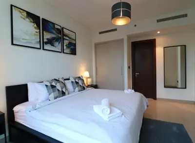 a bedroom with a large white bed with a hat on it at Luminous 2 BR - Sobha Reserve in Dubai