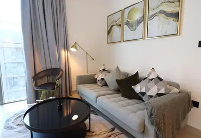 a living room with a couch and a table at Luminous 2 BR - Sobha Reserve in Dubai