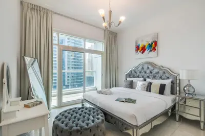 a bedroom with a bed and a large window at Peaceful Waterfront Marina View in Dubai