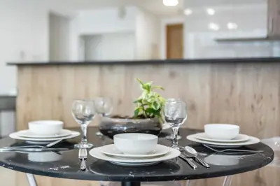 a table with plates and wine glasses on it at Peaceful Waterfront Marina View in Dubai
