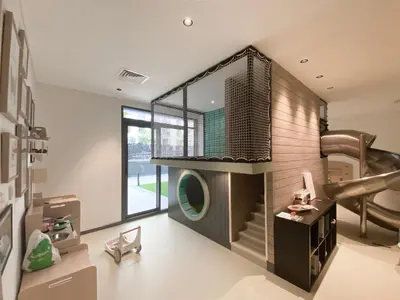 a living room with a staircase and a large window at Sophisticated 1BR with Pool View in Belgravia Square JVC in Dubai